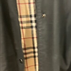 Woman’s Burberry Black Trench Coat with plaid accents and hood.